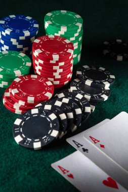 Değişik renklerde poker çipleri koyu yeşil keçeli yüzey üzerinde üç asla yan yana dizilir. Arkadaşlarla oyun gecesinin heyecanlı bir anını vurgularlar..