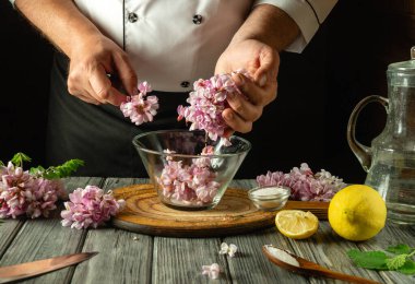 Becerikli bir şef narin çiçekleri narenciye ve tuzu sıcak bir atmosferde taze malzemeler ve mutfak aletleriyle çevrili cam bir kasede ustalıkla birleştirir. Akasya ile kvass yapmak.