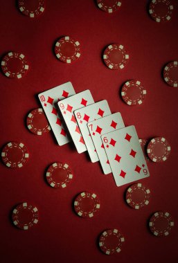 Elmas takımların yer aldığı beş kart, bir kumar gecesi boyunca kırmızı poker fişleri ile çevrelenmiş, 6 'dan 10' a kadar sıralı olarak düzenlenir..