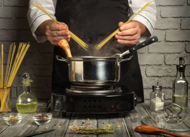 Çağdaş bir mutfakta şef taze malzemeler hazırlarken kaynar suya makarna ekleyerek spagetti pişirir. Yemekler ustalıkla terbiye edilirken aromalar boşluğu dolduruyor..