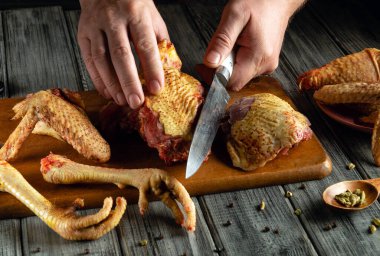 Eller, kırsal bir mutfakta ustalıkla taze kümes hayvanları kesip hazırlıyorlar. Dikkatimizi kuşun çeşitli kısımlarını kesme ve sergileme sürecine yoğunlaştırdık..