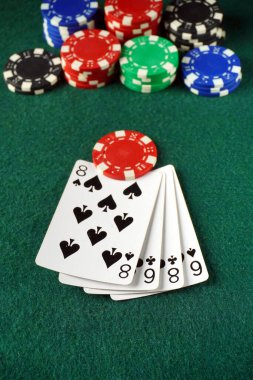 Oyuncular dört sekizli gösteren, renkli poker fişleriyle çevrili olağanüstü bir ele odaklanıyorlar. Yerel bir kumarhanede oyun başlarken ortam gergin..