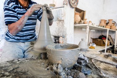 Skillful potter forming a vessel out of gray clay in a pottery factory, Fez, Morocco, North Africa