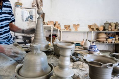 Skillful potter forming a vessel out of gray clay in a pottery factory, Fez, Morocco, North Africa