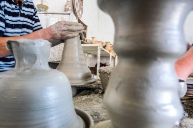 Skillful potter forming a vessel out of gray clay in a pottery factory, Fez, Morocco, North Africa