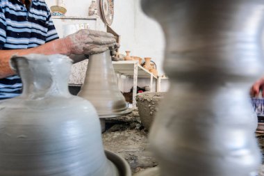 Skillful potter forming a vessel out of gray clay in a pottery factory, Fez, Morocco, North Africa