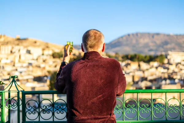 Man on the rooftop enjoying view of Fez old arabic medina, Morocco, North Africa