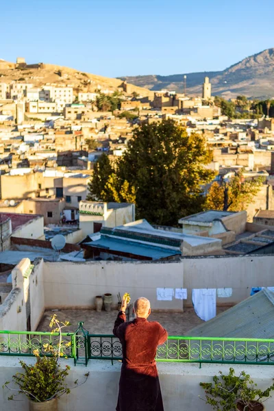 Man on the rooftop enjoying view of Fez old arabic medina, Morocco, North Africa