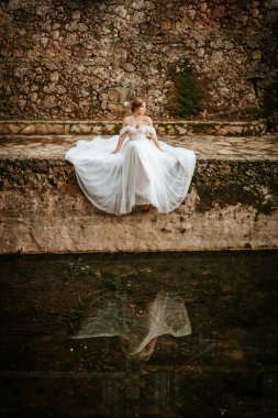 Taş nehir kıyısında güzel bir gelinin hayali portreleri.