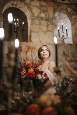 Çiçekler ve mumlarla süslenmiş güzel gelin.