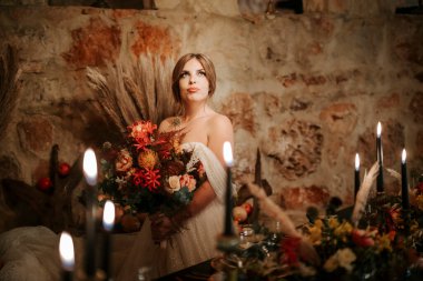 Çiçekler ve mumlarla süslenmiş güzel gelin.