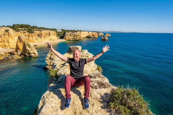 Щасливий Чоловік Сидить Руками Вершечку Скель Пляжі Марінья Алгарве Португалія — стокове фото
