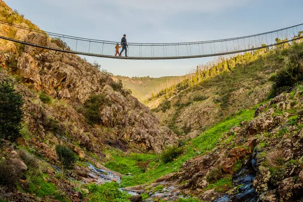 stock image Father and son walking on hanging bridge in Alferce, Algarve, Portugal