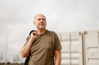 Albufeira, Algarve, Portekiz 'de endüstriyel arka planda poz veren beyaz adam.