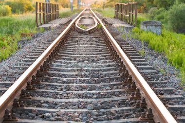 Gün batımında kırsalda demiryolu rayları ve raylar