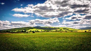 Dağları ve mavi gökyüzü olan güzel bir manzara.
