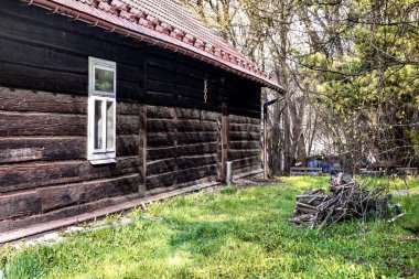 Penceresi ve bir odun yığını olan ahşap bir kulübe.