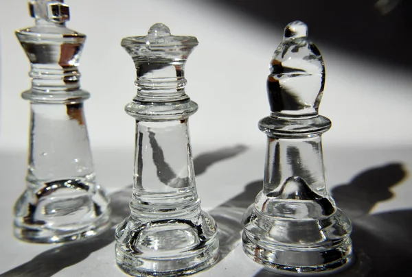 King, Queen and Bishop - Glass Chess Pieces in Formation - Closeup, Light and Shadow