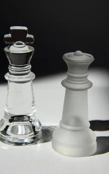 King and Queen - Glass Chess Pieces in Formation - Closeup, Light and Shadow