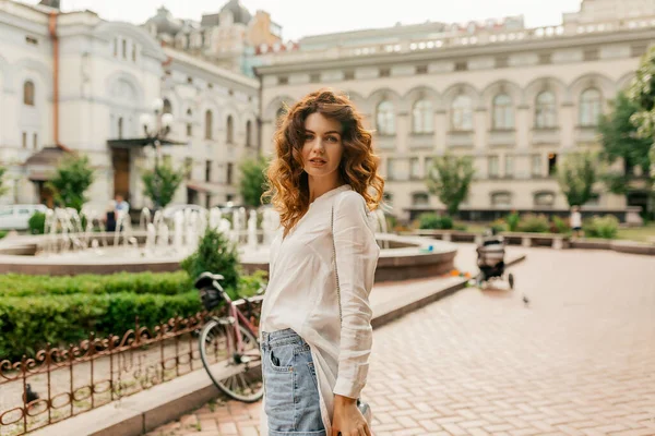 유럽의 도시를 걸어다니는 카메라를 코카서스 여자는 블라우스와 반바지를 입는다 휴가를 — 스톡 사진