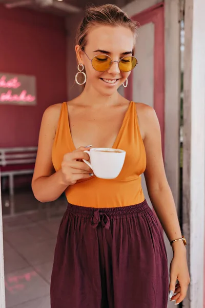 식당에서 커피와 나오는 미소를 아름다운 여성의 그녀는 주황색 티셔츠를 주황색 — 스톡 사진