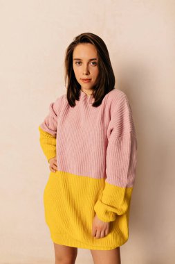 Siyah saçlı ve makyajlı harika bir kadın dar örülmüş bahar elbisesi giyiyor izole edilmiş arka planda kameraya poz veriyor ve güzel bir gülümsemesi var. 