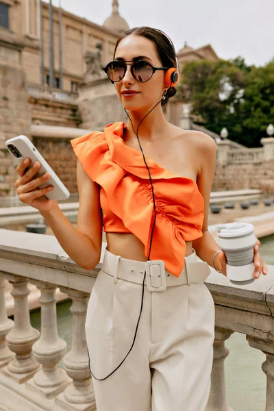 매력적 잘생긴 머리를 매력적 여자가 주황색 안경은 음악을 도시에서 시간을 — 스톡 사진