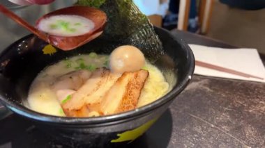Lokantadaki siyah kasede lezzetli ramen erişteleri. Japon ve Çin geleneksel yemekleri, erişteli domuz çorbası ve yumurta. - Evet. Lezzetli erişteler, siyah bir kasede.