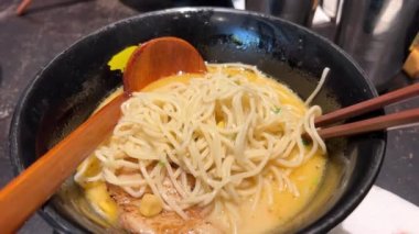 Lokantadaki siyah kasede lezzetli ramen erişteleri. Japon ve Çin geleneksel yemekleri, erişteli domuz çorbası ve yumurta. - Evet. Lezzetli erişteler, siyah bir kasede.