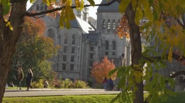 Scenic view of historical landmark McGill University during fall season in Montreal. People walking on the streets and enjoing warm weather. Montreal, QC Canada October 22, 2022