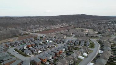 Aerial drone view of Canadian suburban neighborhood at daytime early spring. Establishing shot of Canadas suburb. Residential single family houses pattern, trees