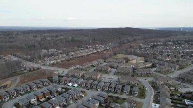 Aerial drone view of Canadian suburban neighborhood at daytime early spring. Establishing shot of Canada's suburb. Residential single family houses pattern, trees.
