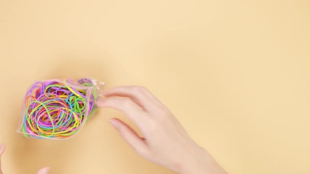 Руки Вынимают Красочные Резиновые Ленты Маленького Пластикового Пакета Помещают Желтый — стоковое видео