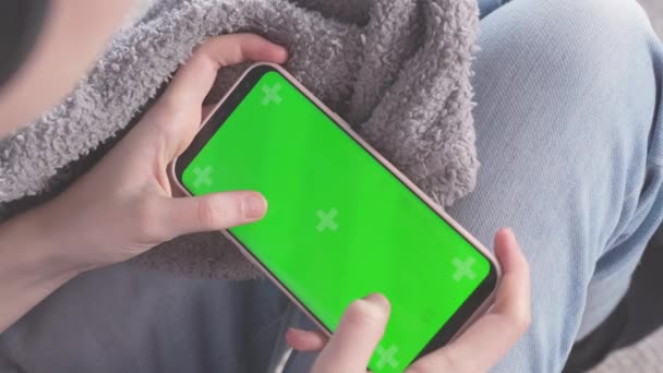 10代の女の子は緑の画面で携帯電話でゲームをプレイ コピースペースのための緑の画面とクロマキーを持つ電話 クロマキーは追跡マーカーでモックアップします タップして画面中央をクリックします — ストック動画