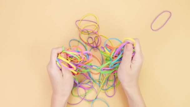 Hands Taking Bunch Colorful Rubber Bands Squizzing Them Yellow Background — Video Stock
