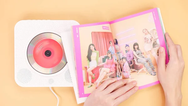 stock image Hands holding Twice Between 1 and 2 mini Album photobook on yellow. Music CD player. South Korean girl group Twice. Space for text. Gatineau, QC Canada - December 27 2022