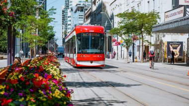 Toronto 'nun eğlence bölgesinde yeni TTC Bombardıman Arabasının sokak manzarası. Toronto caddelerinde yeni Toronto Transit Commision tramvayı. TORONTO, Kanada - 4 Temmuz 2022