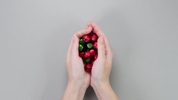 Ruce Ukazující Červené Zelené Rolničky Vánoční Ozdoby Šedém Pozadí Koncept — Stock video