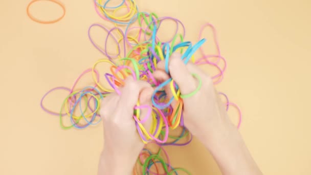 Hands Taking Bunch Colorful Rubber Bands Squizzing Them Yellow Background — ストック動画