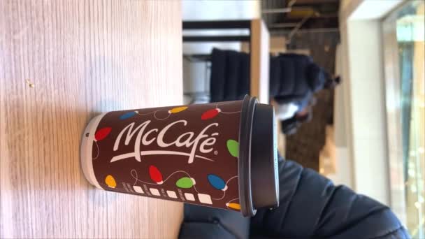 マンスハンドは マクドナルドのファストフードレストランでクリスマス マッカフェのコーヒーカップを取っています ホリデーペーパーカップ ホリデーショッピング カナダ オタワ 2022年11月20日 — ストック動画