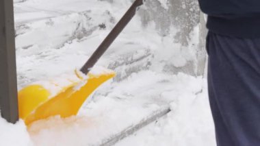 Kanada 'daki kış fırtınasından sonra garaj yolundaki karları temizleyen adam. Kar kürekli adam kışın kaldırımları temizler.