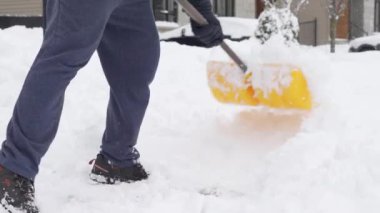 Kanada 'daki kış fırtınasından sonra garaj yolundaki karları temizleyen adam. Kar kürekli bir adam kışın kaldırımları temizler. Kanada 'da Ottawa - 01-14-24.