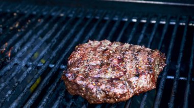 Lekesiz ızgara barbekü ızgarasında ızgara et ve siyah arka planda alevler. Yiyecek ve mutfak konsepti