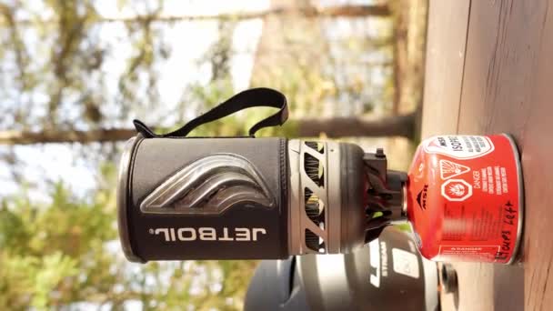 骑摩托车的人在绿树成荫的森林里煮开水 而露营时则在一个即时沸腾的Jetboil和一个小气罐里 垂直录像 — 图库视频影像