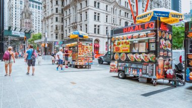 Değişik araçlar, büyüleyici binalar, yeşil ağaçlar ve kentsel yaşamın enerjik özünü özetleyen canlı bir atmosferle dolu hareketli bir New York caddesi..
