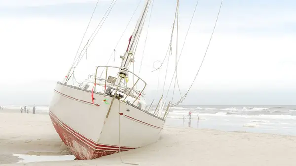 stock image Dramatic Scene of a Yacht Stranded on a Sandy Beach After a Destructive Hurricane Storm - Jacksonville, Florida USA 03.15.2024.