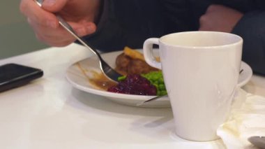 Beyaz tabakta patates kızartması ve sebzeyle servis edilen köfteler..