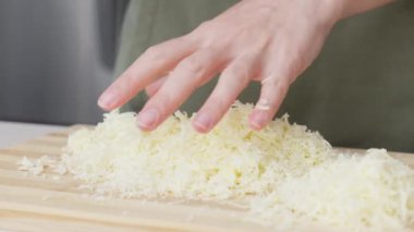 Izgara peynir aşçının elinden düşer. Pizza için rendelenmiş peynir.