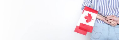 Minyatür bir Kanada bayrağı izole edilmiş beyaz arka planda kot pantolonun arka cebinde duruyor. Bayrak Kanada 'nın bir sembolüdür ve ulusal gururunu göstermek için kullanılır..