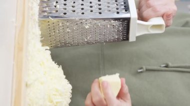 Izgara peynir aşçının elinden düşer. Pizza için rendelenmiş peynir.